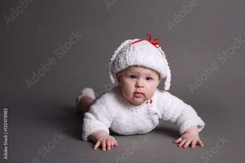 beautiful baby in a knit dress and cap