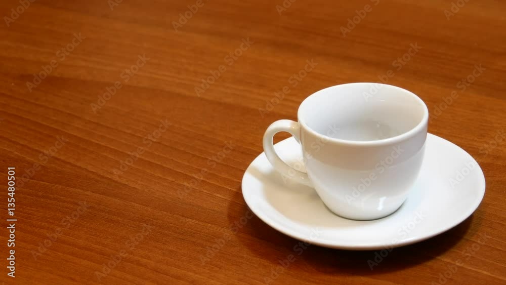 Pouring hot water into a white cup with an instant coffee Pouring hot water into a white cup with an instant coffee