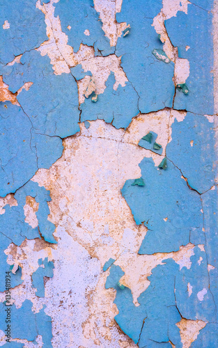 Plastered surface of the wall with peeling blue paint