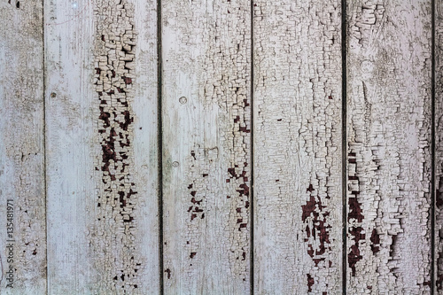 The surface of old boards with peeling white paint.