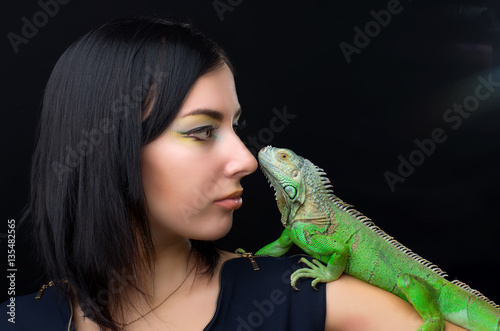 Beautiful girl portrait and green iguana in the studio