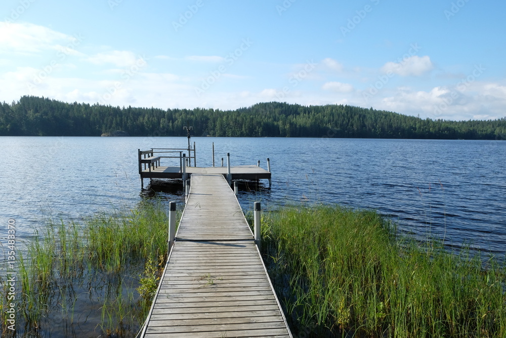 Naklejka premium Pier on the shore of the lake near the village Antolla