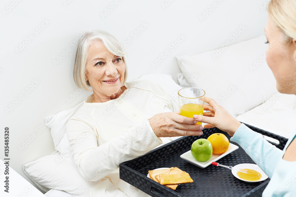 Old woman eating breakfast in bed