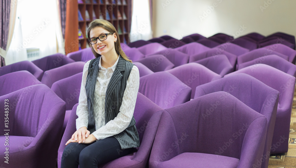Fototapeta premium A beautiful business woman sitting alone in an auditorium
