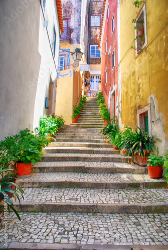 Fototapeta Naklejka Na Ścianę i Meble -  Narrow european street with cobblestone steps and old houses, Portugal