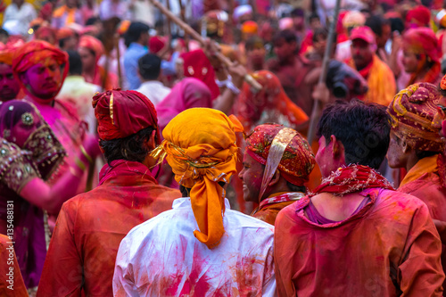 Fotografie Very colorful celebration of Holi festival in India by beating men with Bamboo s