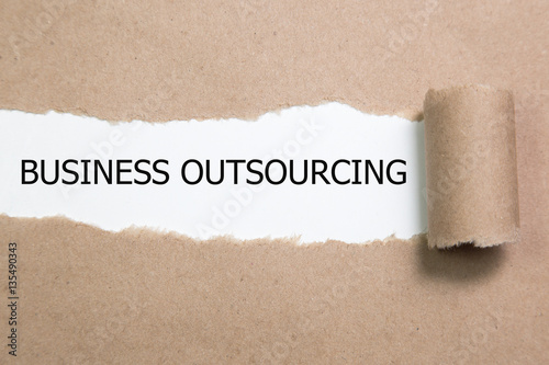 business outsourcing Message written under torn paper.