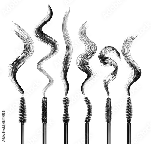Set of various mascara brushes with strokes on white photo