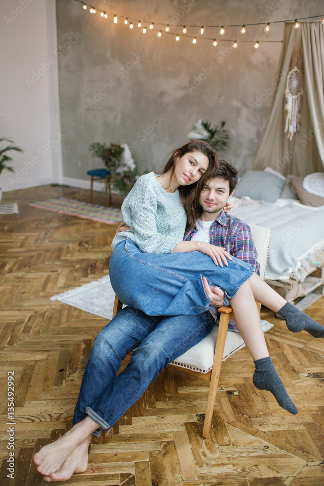 Young hipster couple having fun on old armchair with dreamcatche Young hipster couple having fun on old armchair with dreamcatche