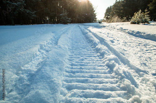 traces of a snowmobile on snow sun