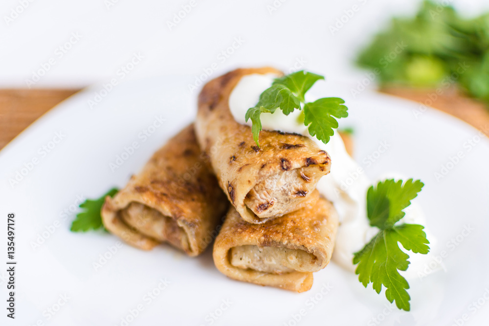 Pancakes filled with meat stuffing on a white plate