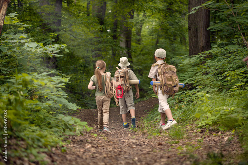 boys and girl on camping trip in the forest exploring