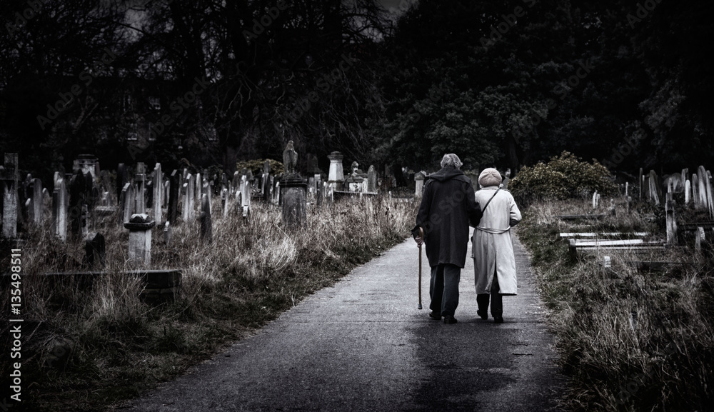 Brompton, London - An elderly couple walk hand-in-hand through a graveyard Brompton, London - An elderly couple walk hand-in-hand through a graveyard
