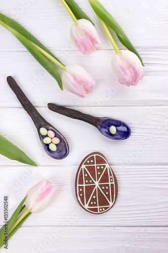 Happy holiday. Easter eggs, gingerbread and pink tulips on white background