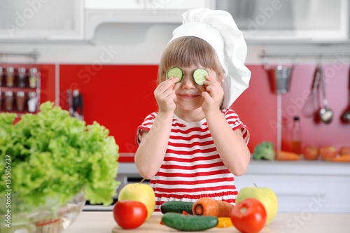 Small girl playing with veg...