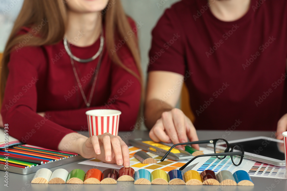 Young decorators sitting at desk in office
