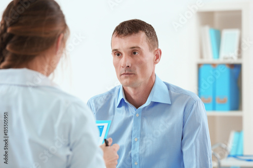 Young man visiting doctor at hospital