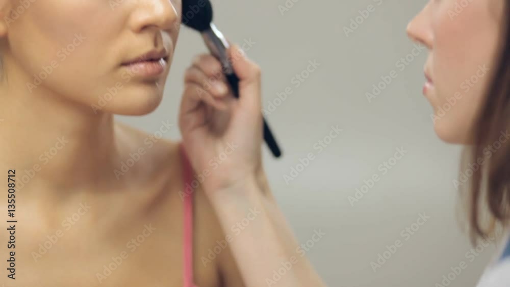 Makeup artist applying makeup on cheekbones. Panning Makeup artist applying makeup on cheekbones. Panning