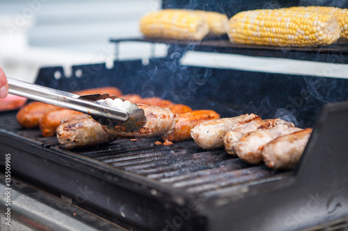 Corn and sausage on a summer gas grill barbecue being cooked