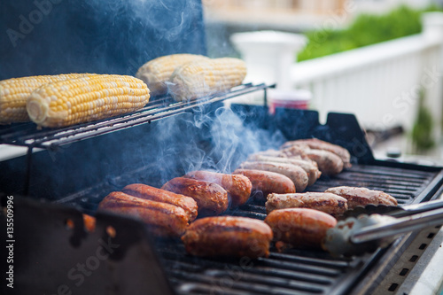 Corn and sausage on a summer gas grill barbecue being cooked