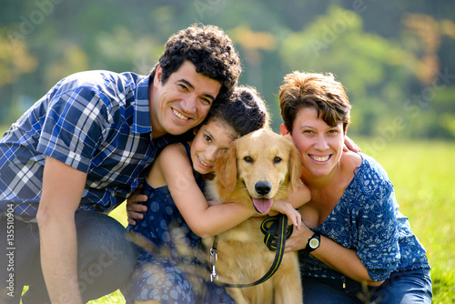 Happy family with a dog on a sunny day on a park
