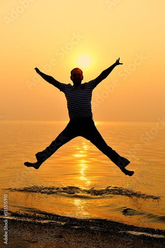 man jumping at sunset