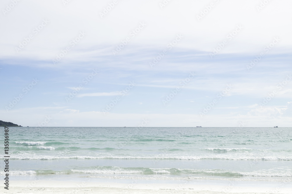 Soft wave of blue and green ocean/sea on sandy beach with bright