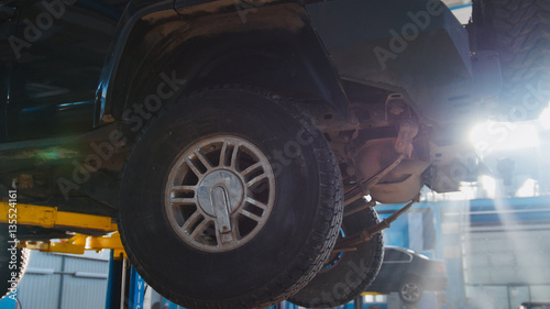 Luxury SUV in garage automobile service - wheel, close up