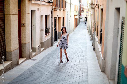 The girl in the dress and hat in the streets of Barcelona