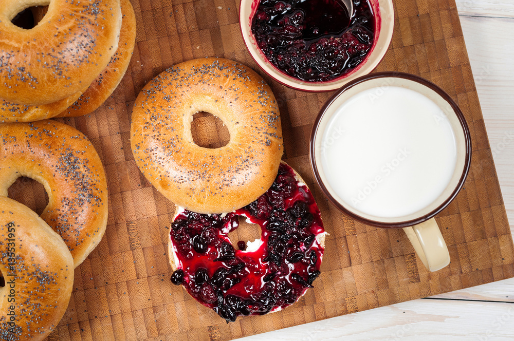 Fresh homemade Poppy bagels bread with cup of milk, cream cheese