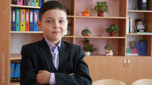 A smiling schoolboy keeping hands crosswise.Mid shot. photo