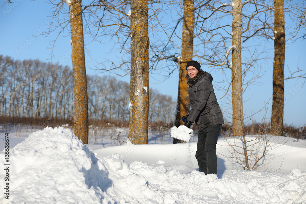 man remove snow with shovel from the road in winter man remove snow with shovel from the road in winter