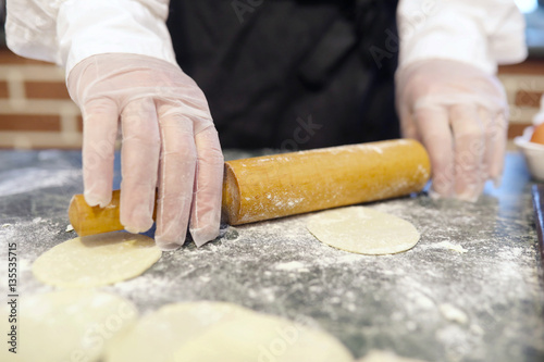Male chef uses ingredients for preparing flour products on kitch