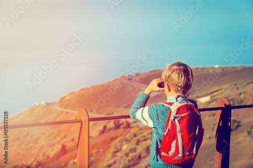 little boy looking at beautiful view while travel in mountains