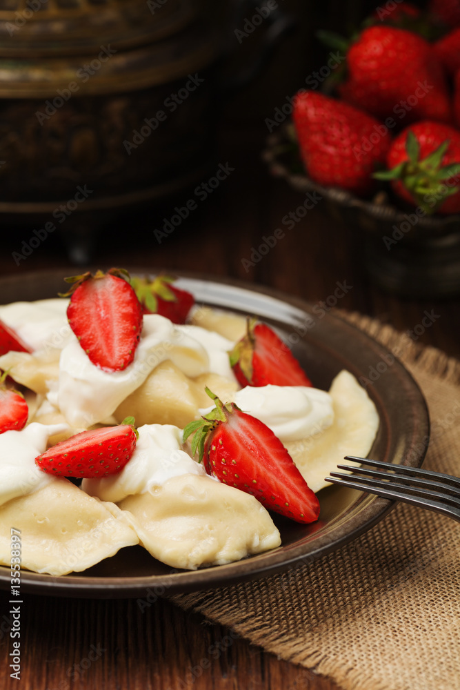 Delicious dumplings with fresh strawberries served with whipped Delicious dumplings with fresh strawberries served with whipped