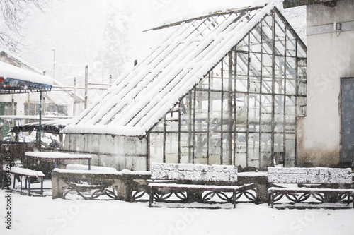 Old, abandoned greenhouse in the snow 