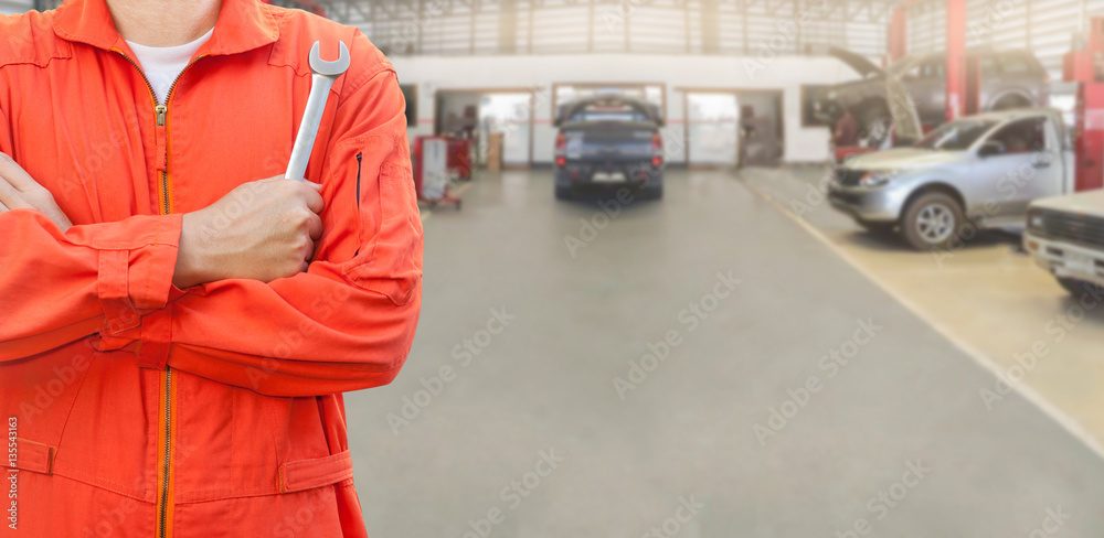 Mechanic holding a wrench in car garage, Mechanic and tools concept. Mechanic holding a wrench in car garage, Mechanic and tools concept.