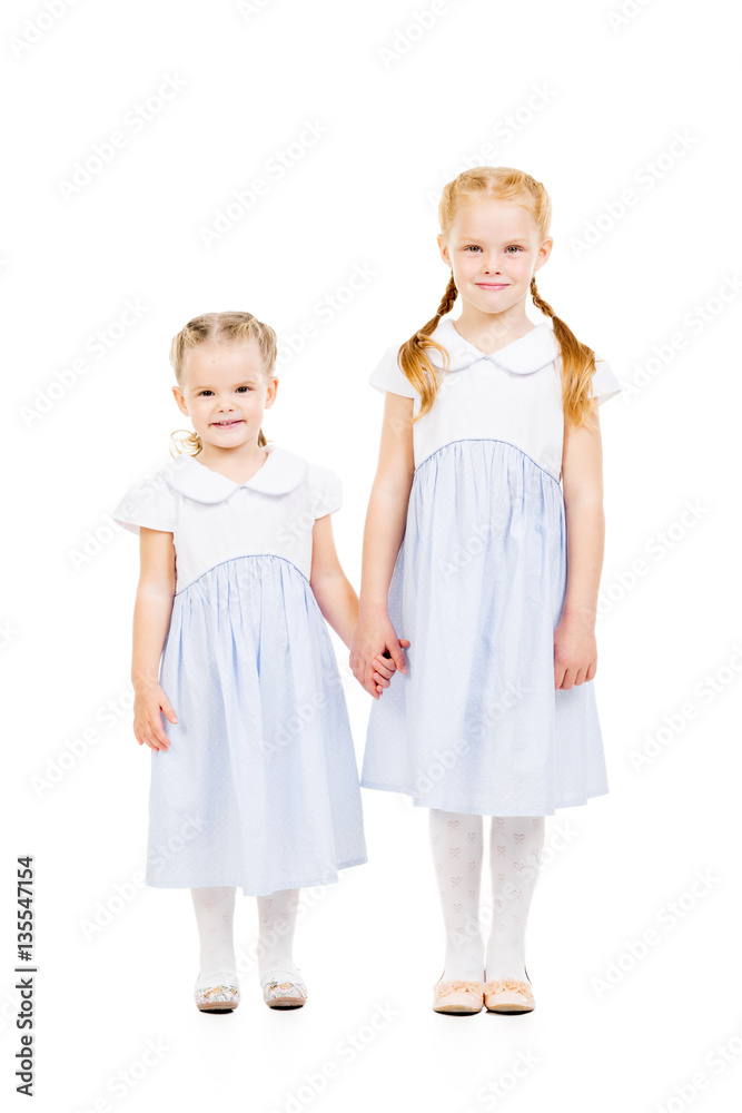Two beautiful sisters in dresses isolated on white. Family, home, love concept.