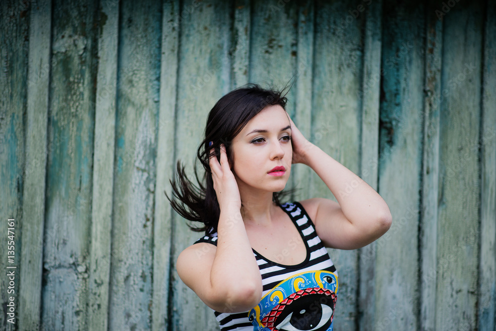 Fototapeta premium Brunette model girl at dress with stripes background cian wooden
