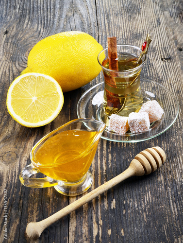 Honey, lemon and a cup of tea on a wooden table