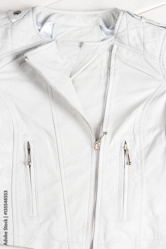 White leather jacket on white background. Leather jacket macro details. Jacket zippers and pockets White leather jacket on white background. Leather jacket macro details. Jacket zippers and pockets