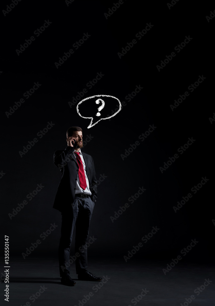 Businessman talking on a mobile phone. Black background with cop Businessman talking on a mobile phone. Black background with cop