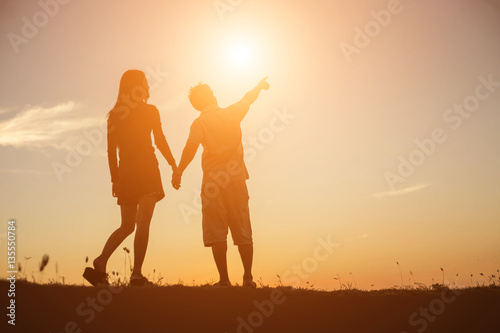  silhouette of a man and woman holding hands with each other  wa