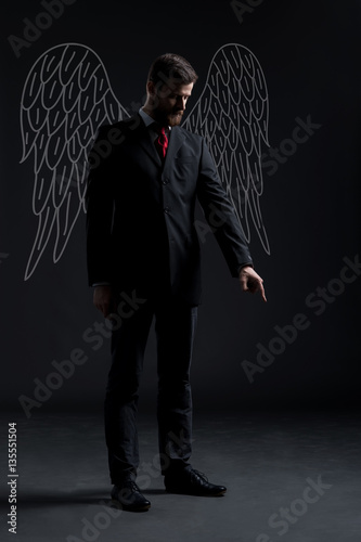 Business angel over dark background. Investment, business, sponsor concept. photo