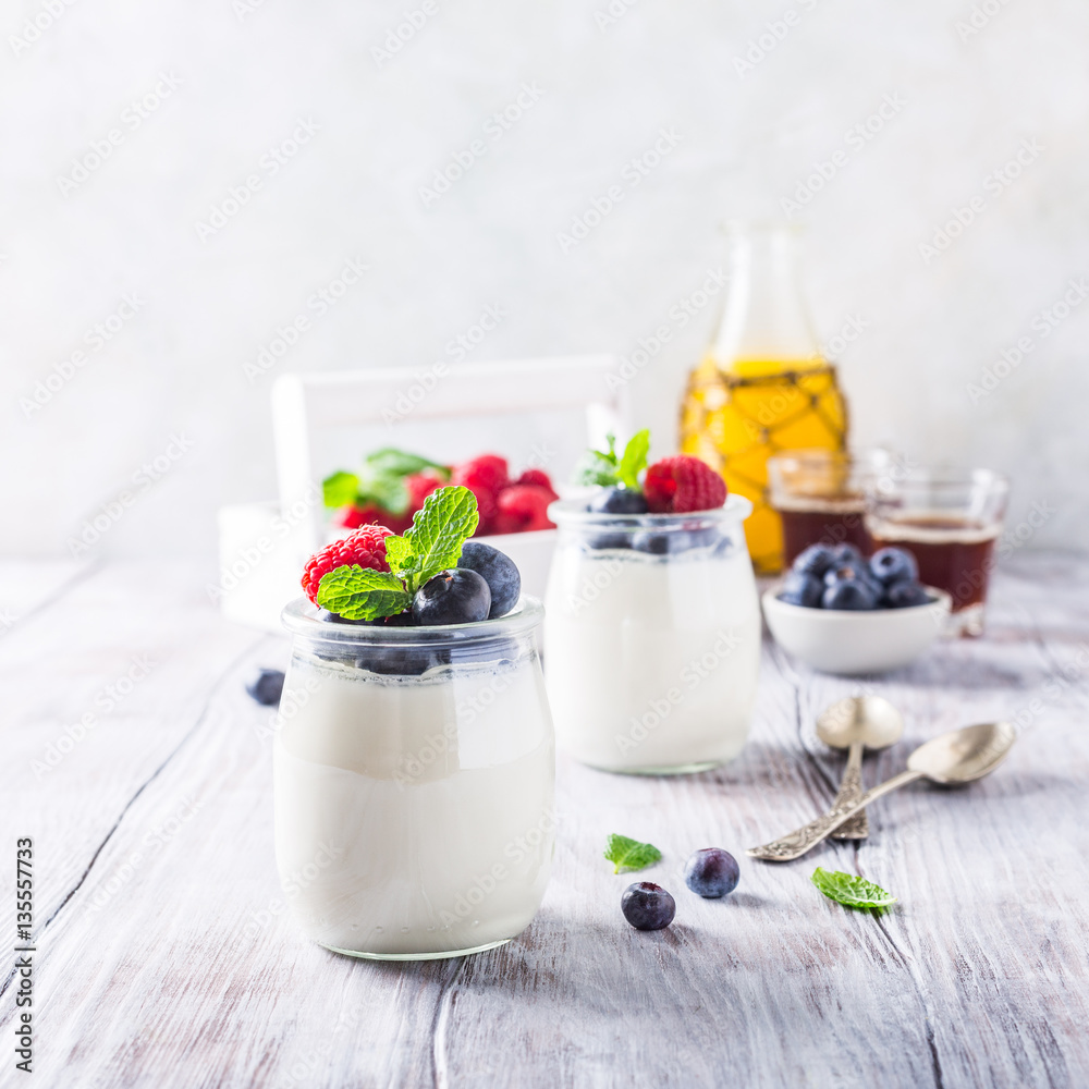 Natural yoghurt with berries on light gray background. Copy space. Healthy breakfast concept. Natural yoghurt with berries on light gray background. Copy space. Healthy breakfast concept.