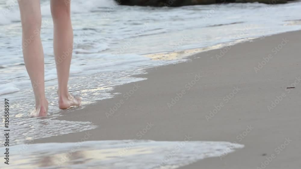 Sea surf, sandy beach front. Feet girl walking on the beach
Sea surf, sandy beach front. Feet girl walking on the beach