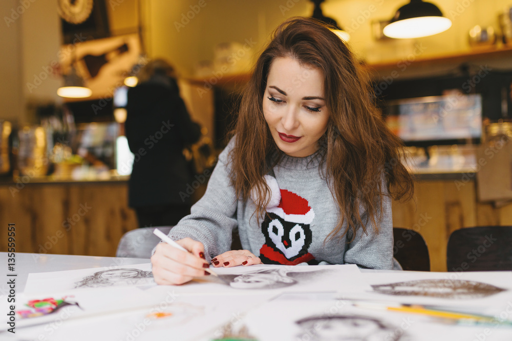 Fototapeta premium beautiful girl drawing with pencil in cafe