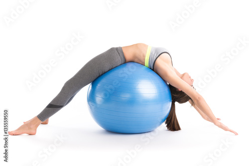 Beautiful fitness woman doing pilates exercises with fit ball. Isolated on white. photo