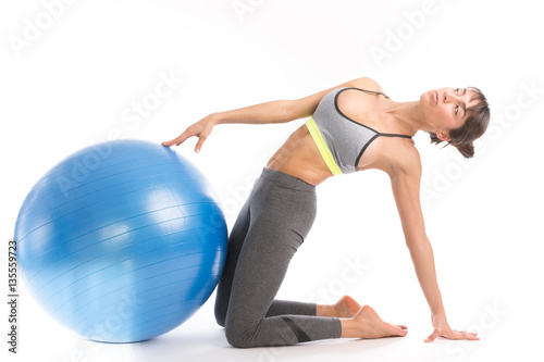 Beautiful fitness woman doing pilates exercises with fit ball. Isolated on white.