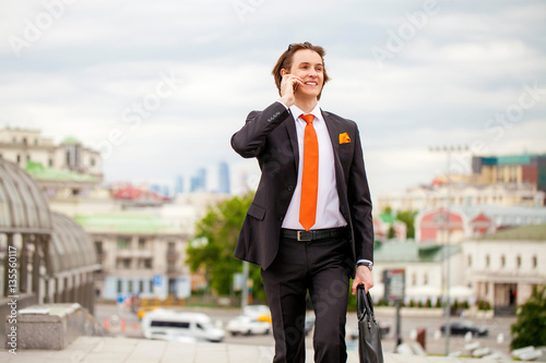 Young successful businessman calling by phone